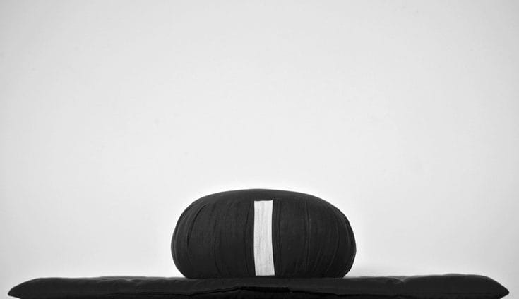 A black cushion on a black mat.