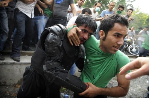 iran-election-by-olivier-laban-matte-afp-getty-11 "A backer of Mir Hossein Mousavi helps evacuate an injured riot-police officer during riots in Tehran on June 13, 2009. (OLIVIER LABAN-MATTEI/AFP/Getty Images)"
