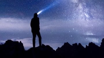 Man with headlamp looking into space.