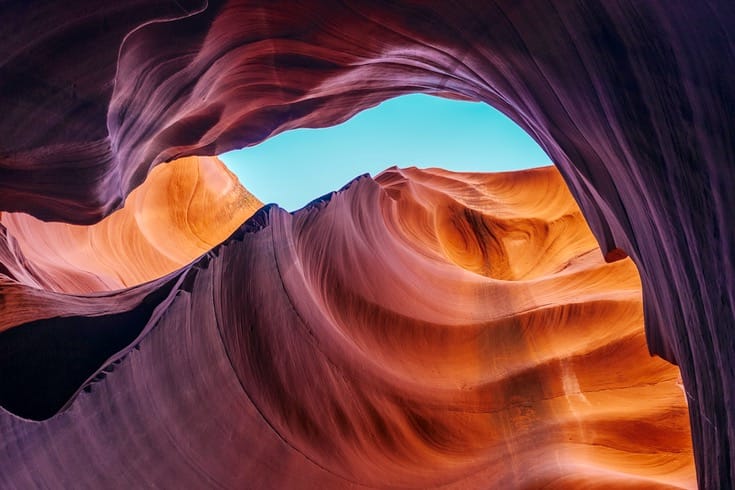 A photo of a canyon. A blue sky is visible through the canyon.