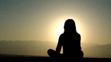 A person meditating in the sun.