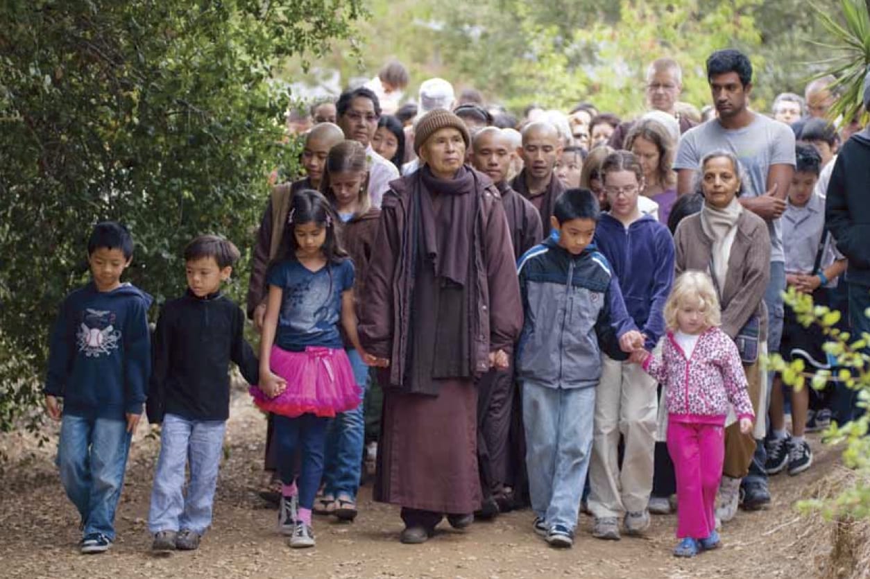 Thich Nhat Hanh walking with a crowd