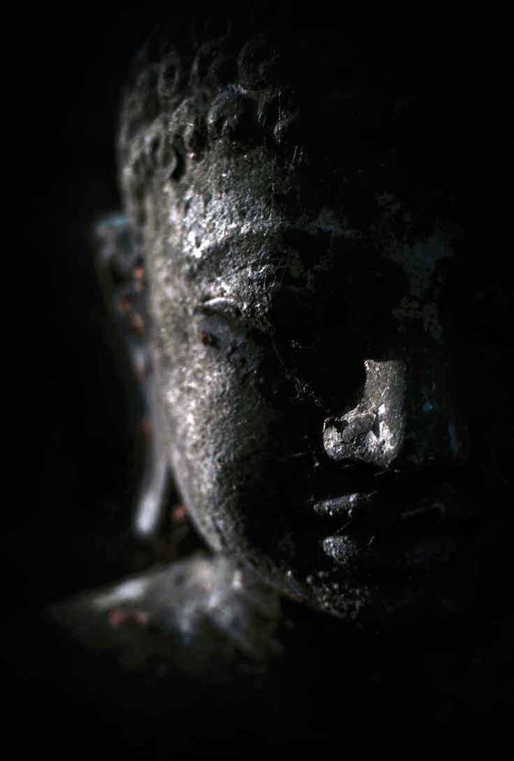 Photo by David Gabriel Fischer. Buddhist head in shadow.