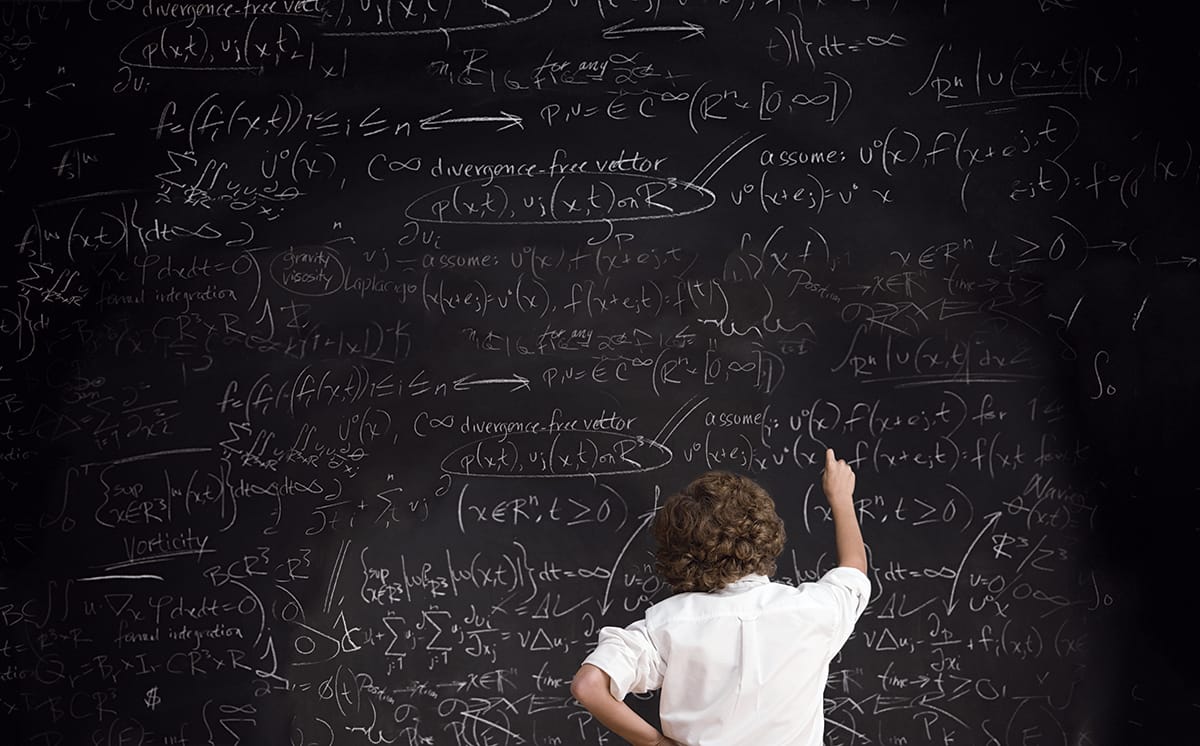 A person in a white shirt drawing on a chalkboard.