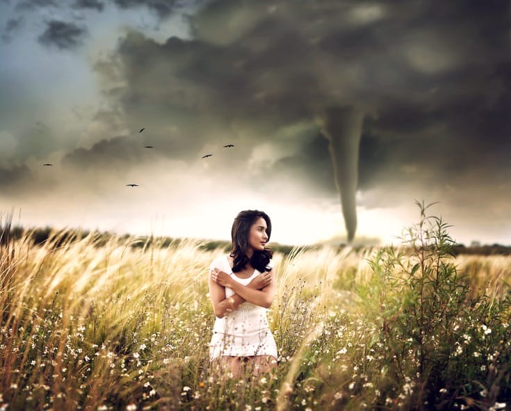 Women standing in front of a tornado.