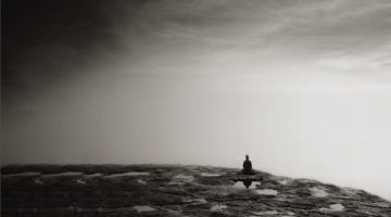 Buddha statue sitting on rocks.