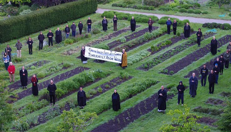 Members of the San Francisco Zen Center hold a sign that reads "Green Gulch Farm Zen Center Temporarily Above Water." Via Eventbrite.