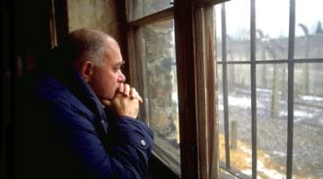 Bernie Glassman staring out of a window at Auschwitz.