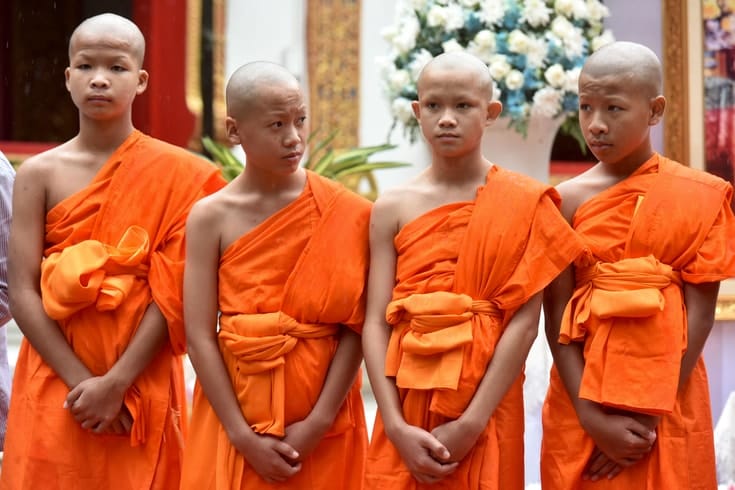 Four young monks standing in a row.