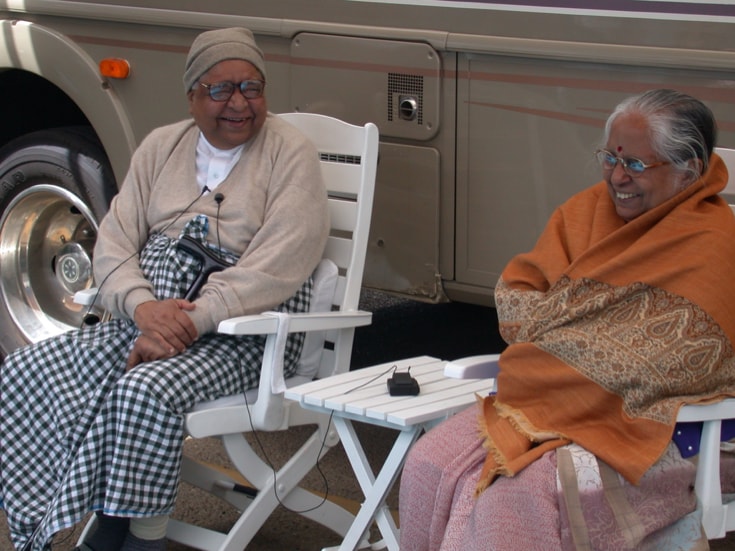 Two people sit in lawn chairs.