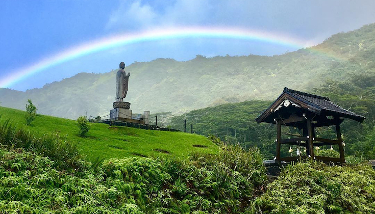 A rainbow over a Buddha statue.