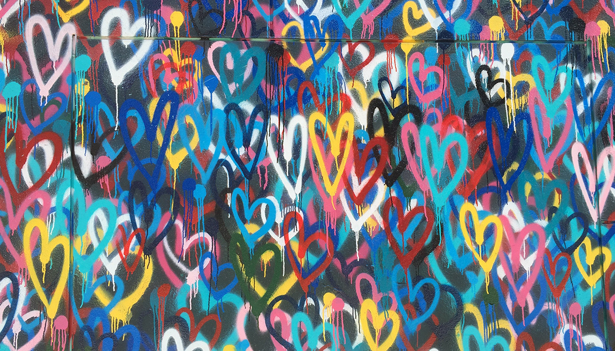Wall covered in spray painted hearts.