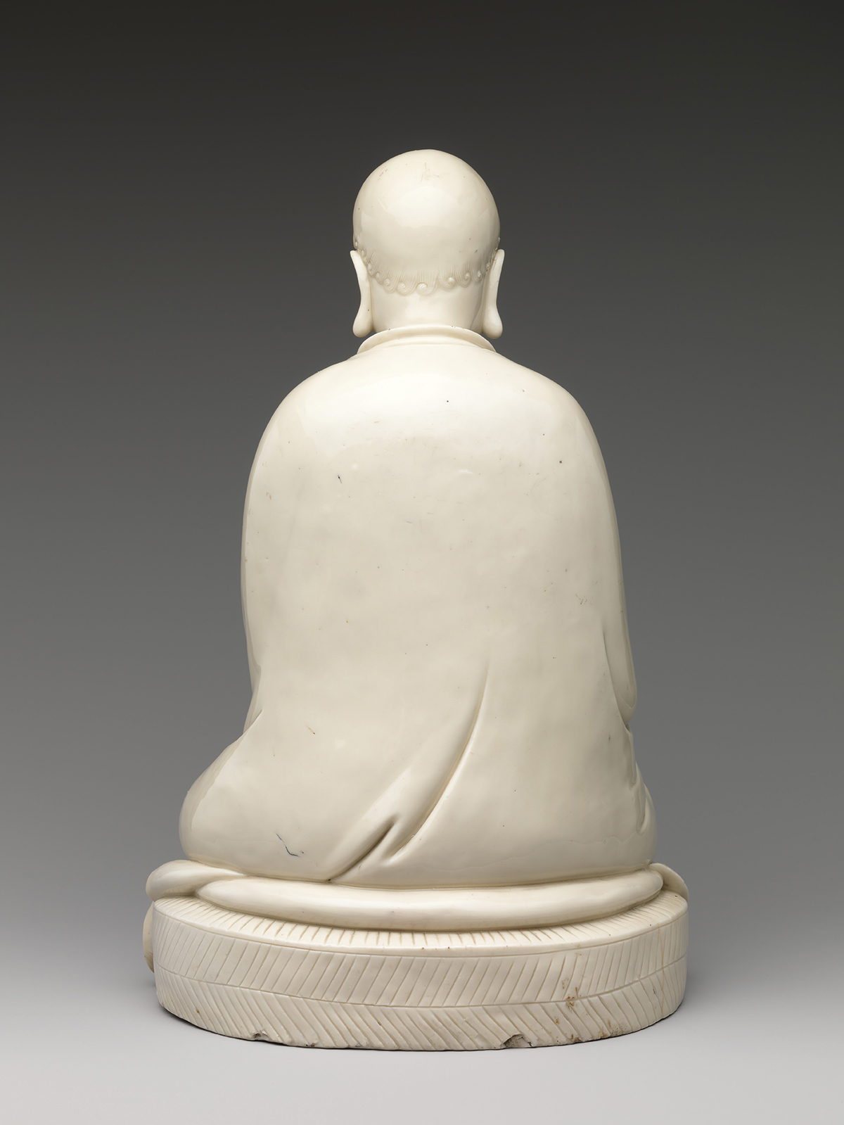 A marble Bodhidharma statue from behind.