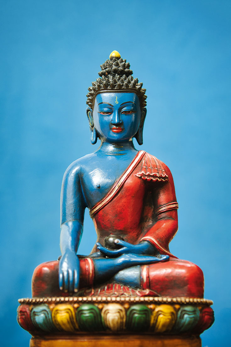 Buddha statue on blue background.