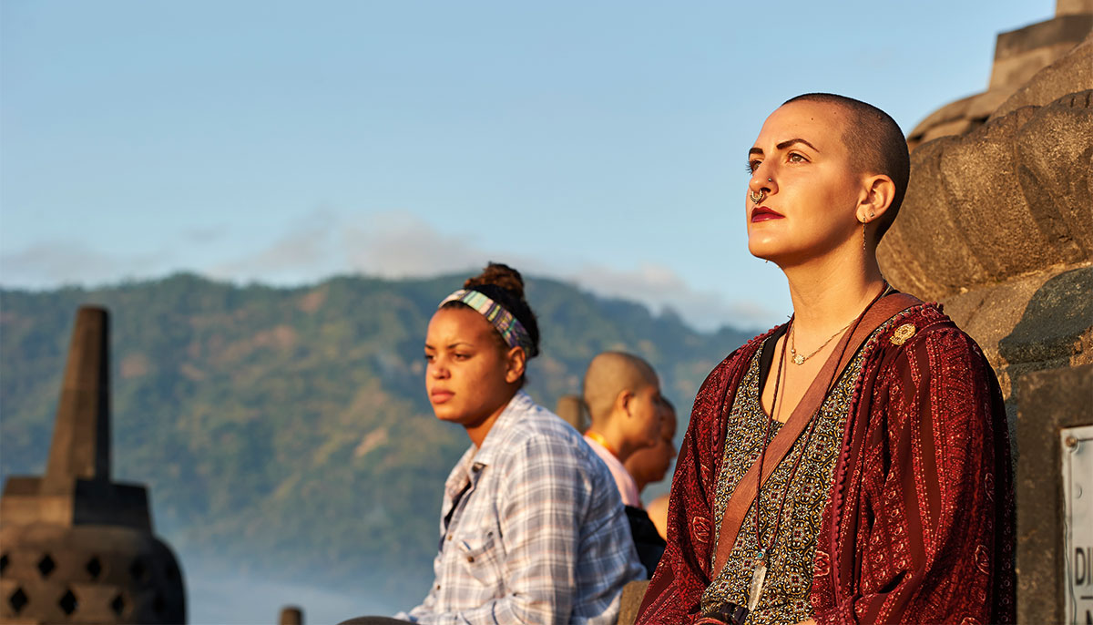 Two women sit outdoors in Indonesia at the Sakyadhita conference